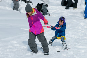 Nayla tows a 5-year-old girl up the ski hill.